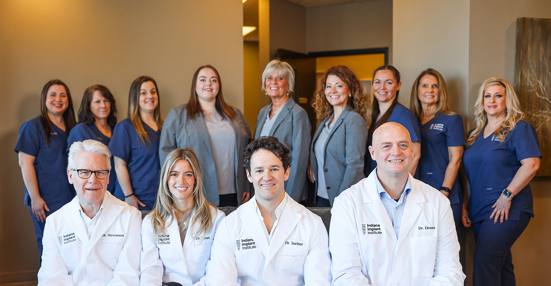 Indiana Implant Institute dental implant specialists Dr. Stevenson, Dr. Dann, Dr. Surber, and Dr. Drone posing with the full clinical team