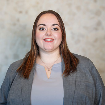 Crystal Anderson, Treatment Coordinator at Indiana Implant Institute, smiling in a grey blazer