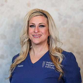 Paulea Connors, Prosthodontic Assistant at Indiana Implant Institute, smiling in blue scrubs